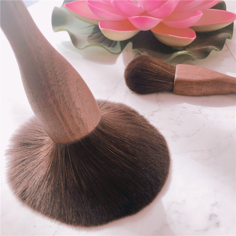 Makeup brush with wooden handle and brown bristles.