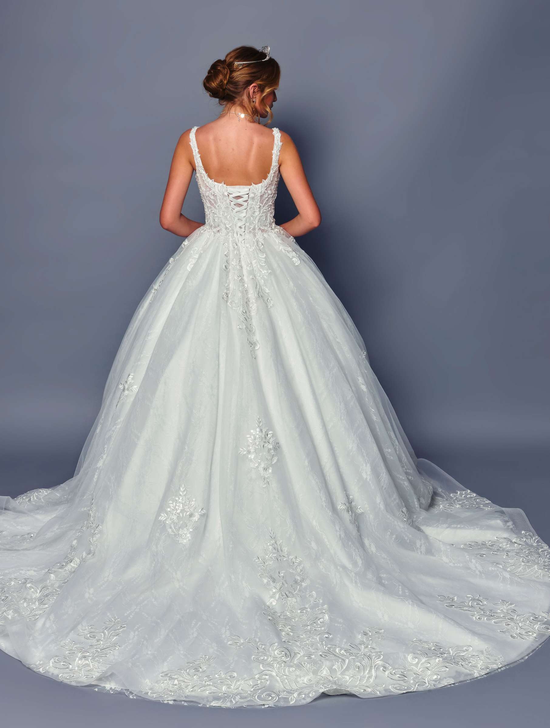 White wedding dress with intricate detailing on a plain background