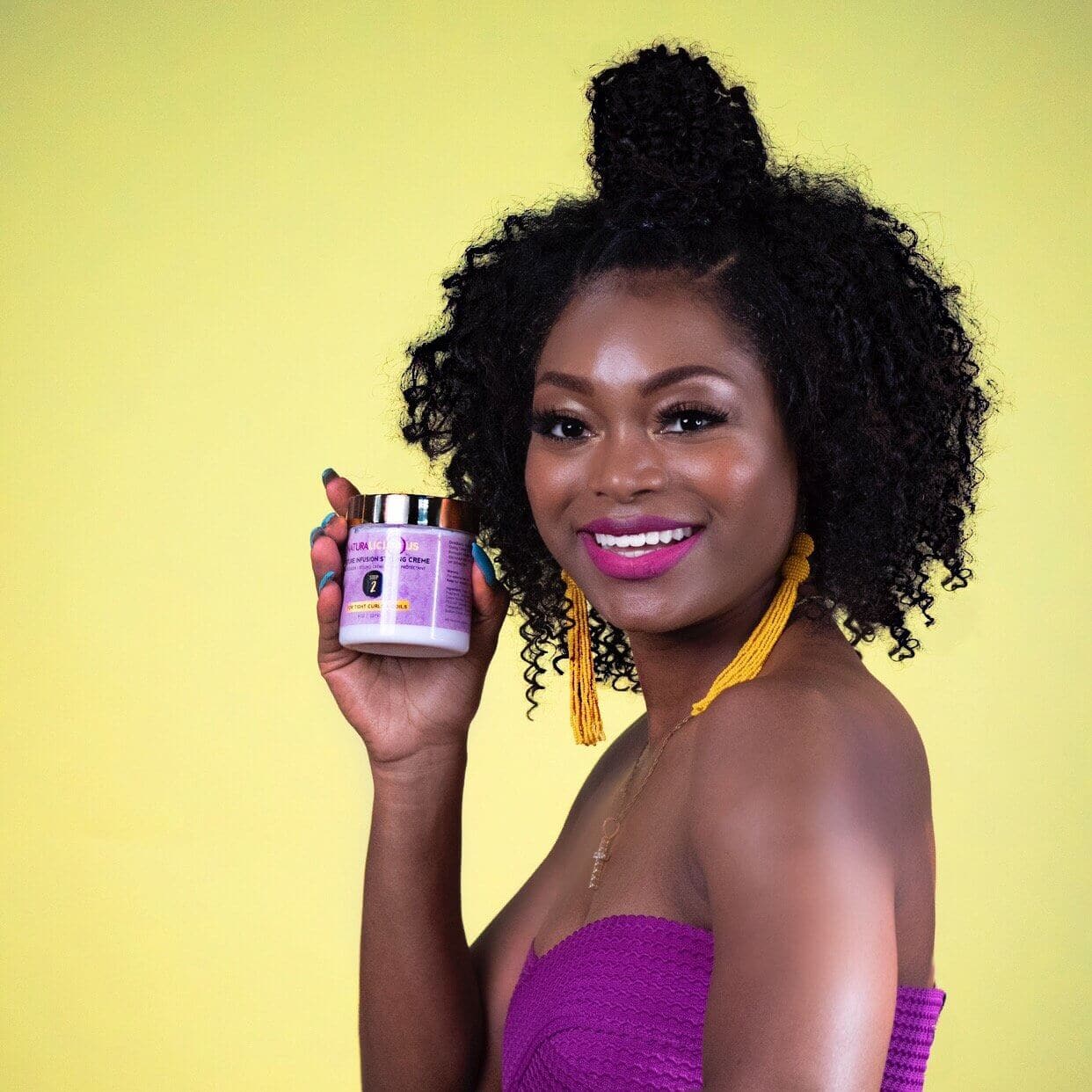 Woman holding a jar of product against a yellow background