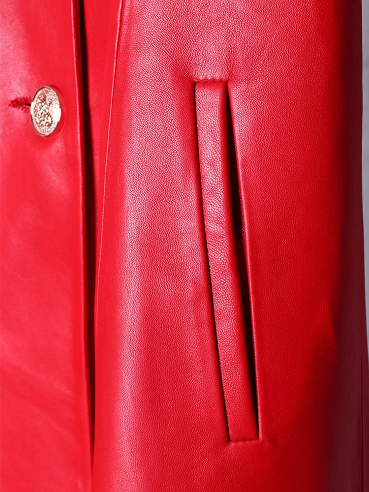 Close-up of a red leather coat with a gold button.