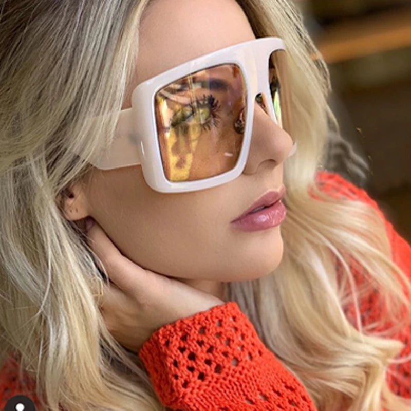 Person wearing large white sunglasses.