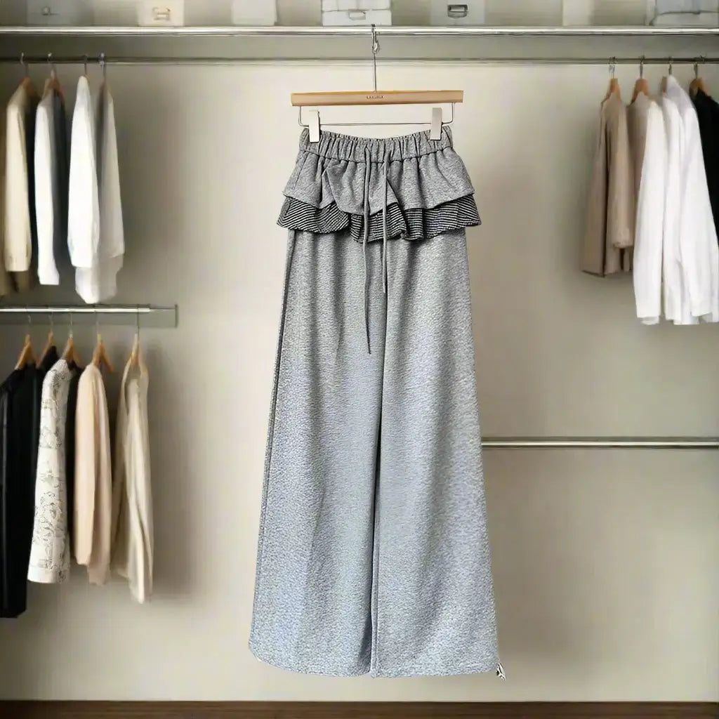 Women's trendy patchwork plaid pants with elastic waistband, hanging in a stylish closet.