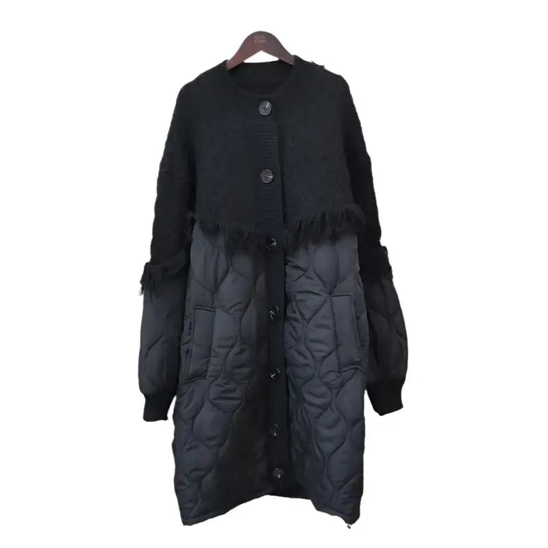 Women's black tassel knit long coat with button-up closure and quilted lower section, stylish and warm for chilly days.