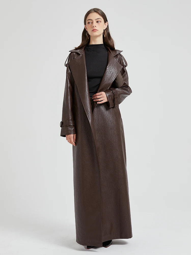 A woman wearing a long brown coat.