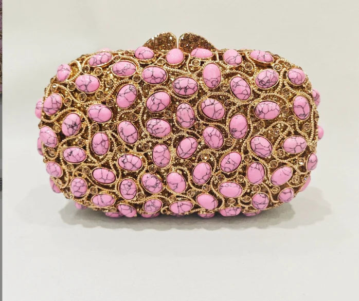 Pink clutch bag with gold accents.