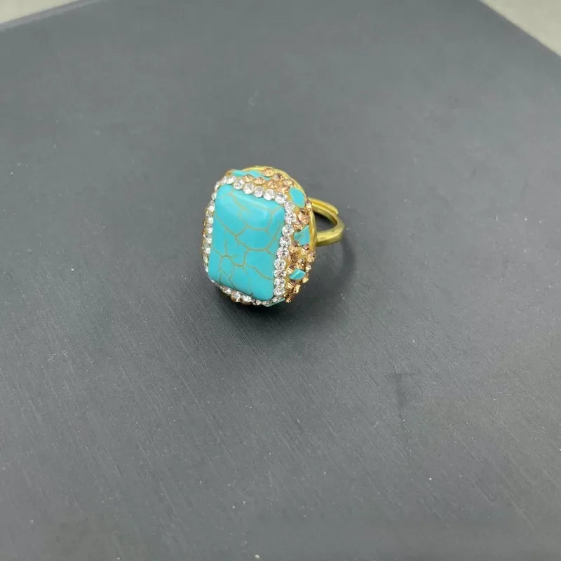 Turquoise ring with gold and clear stones.