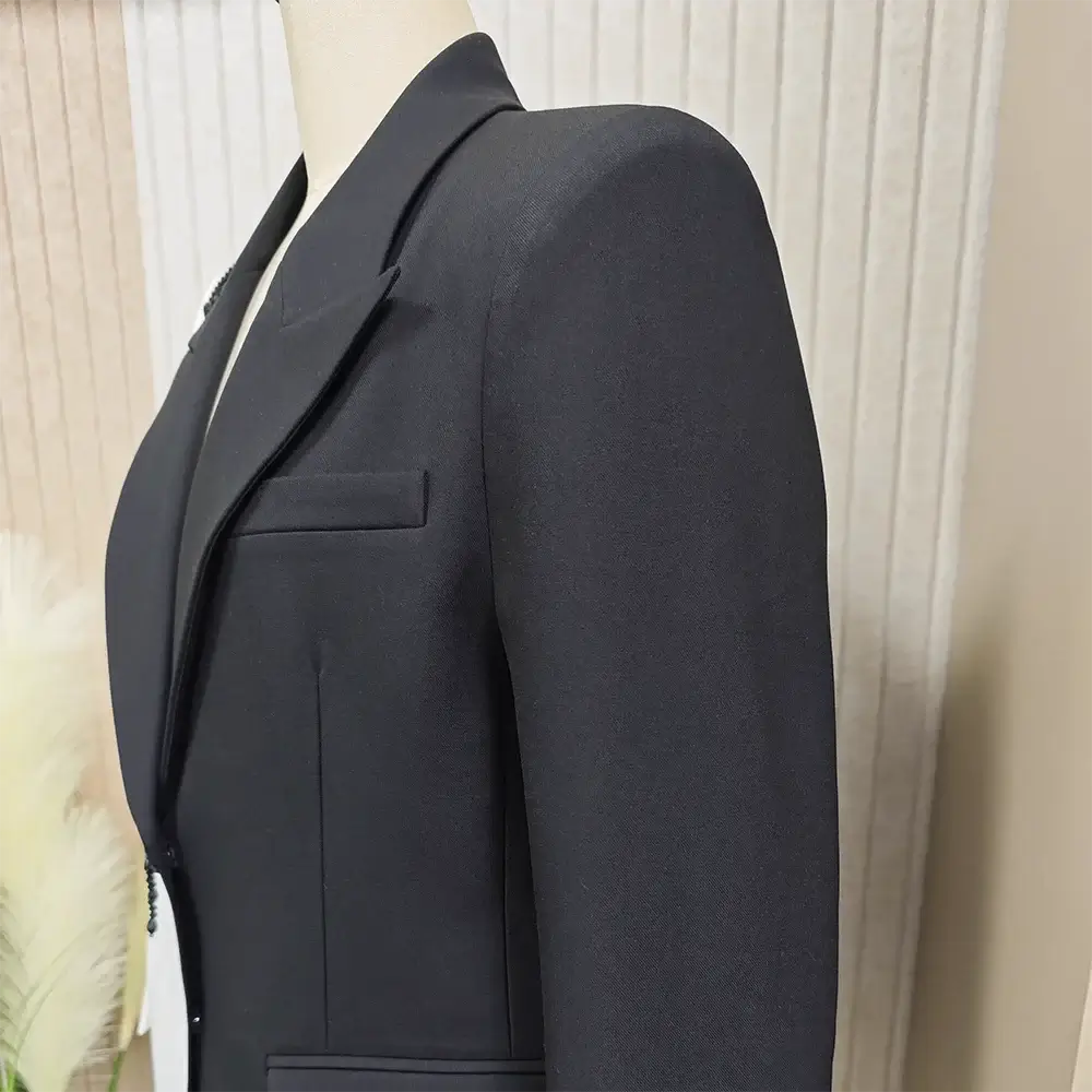 Close-up of a black blazer with a notched collar and tailored fit, showcasing quality craftsmanship and sophistication.