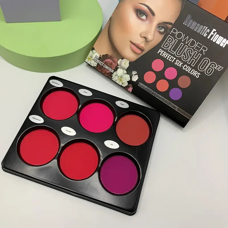 Makeup palette with six red and pink shades and a box .