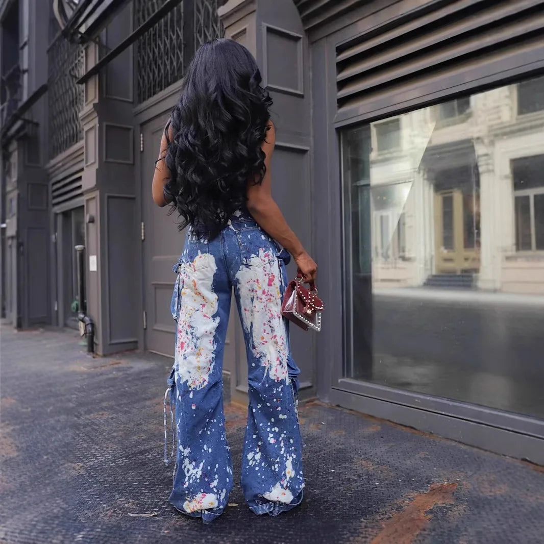 Woman wearing a floral jumpsuit walking on a street.
