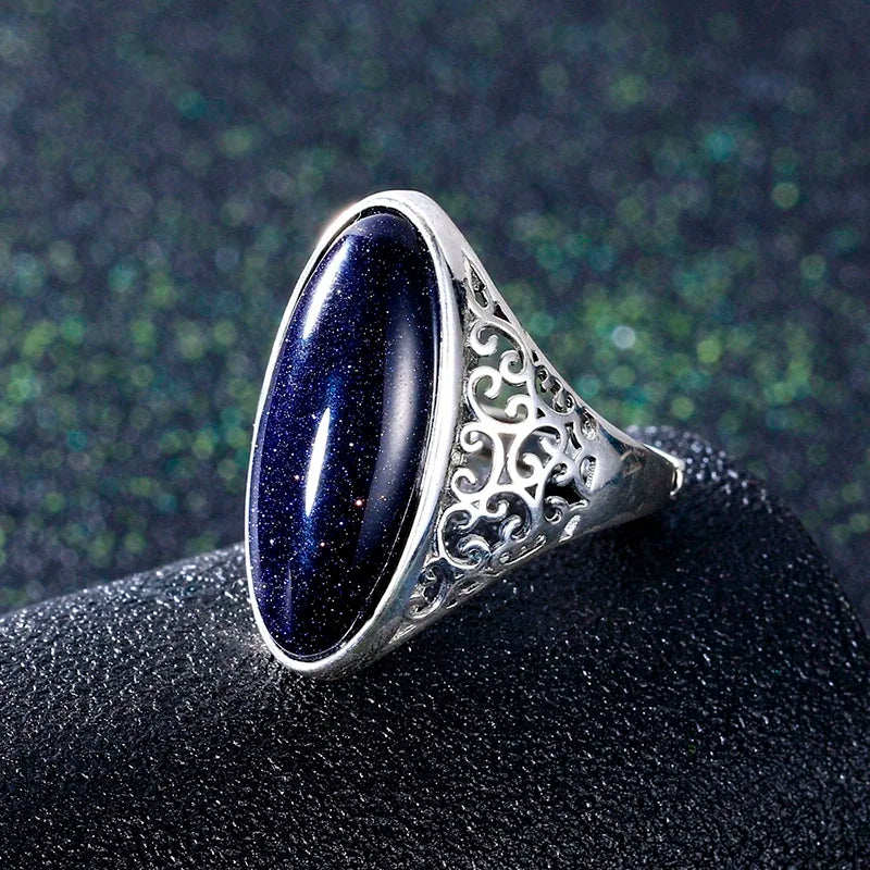 Silver ring with a dark blue stone.