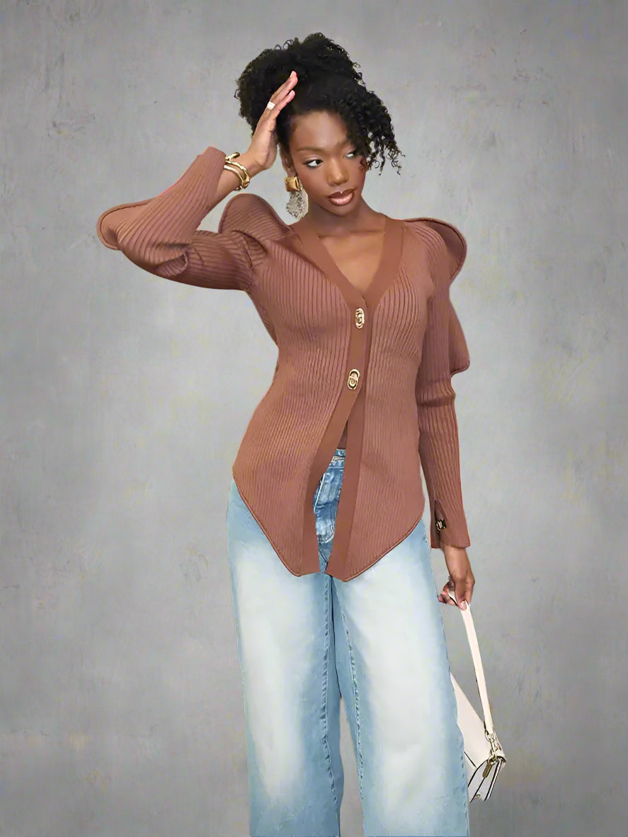 Woman wearing a brown ribbed cardigan and light blue jeans.