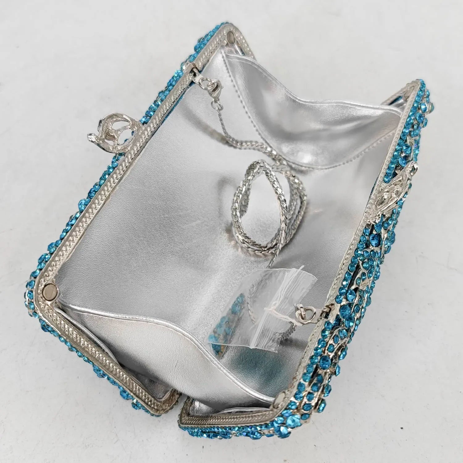 Silver handbag with blue gemstones.
