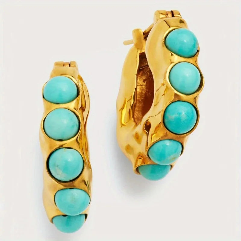 Gold hoop earrings with turquoise stones.