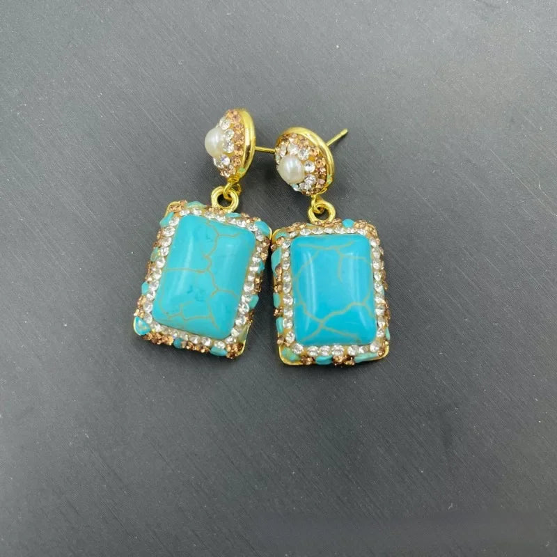 Turquoise earrings with gold accents .