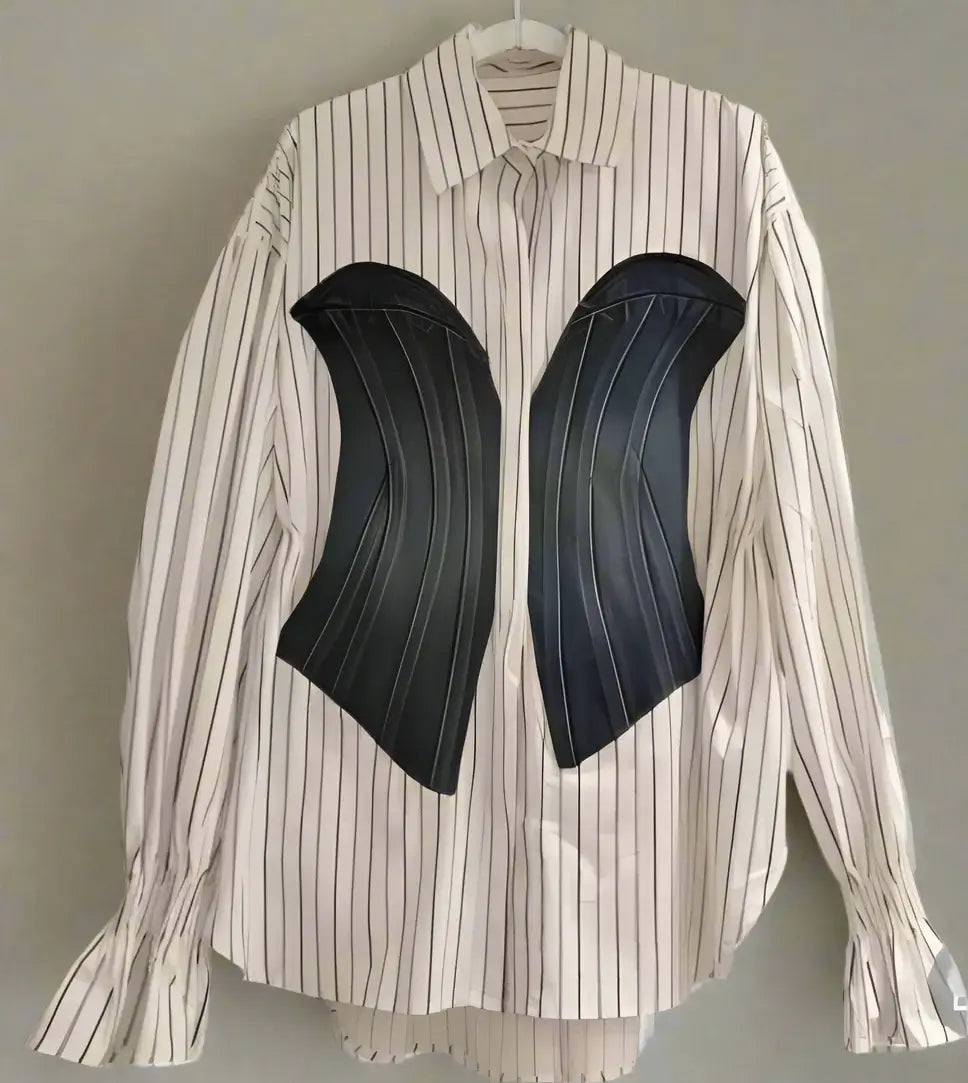 Long sleeved striped blouse with black corset detailing, showcasing modern fashion design.