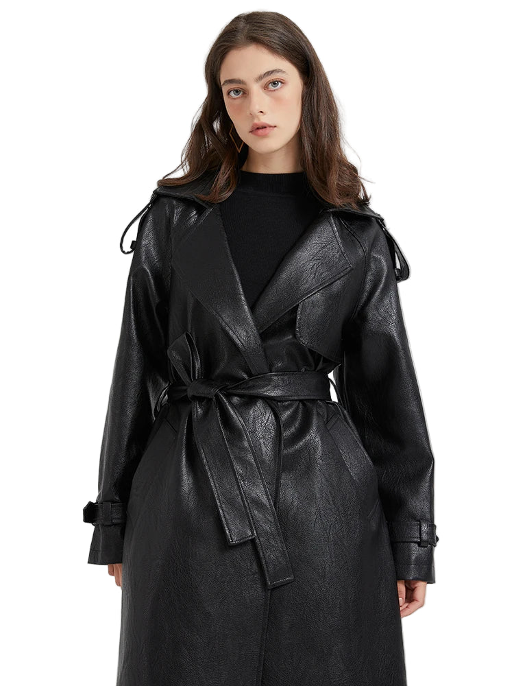 A woman wearing a black leather trench coat.