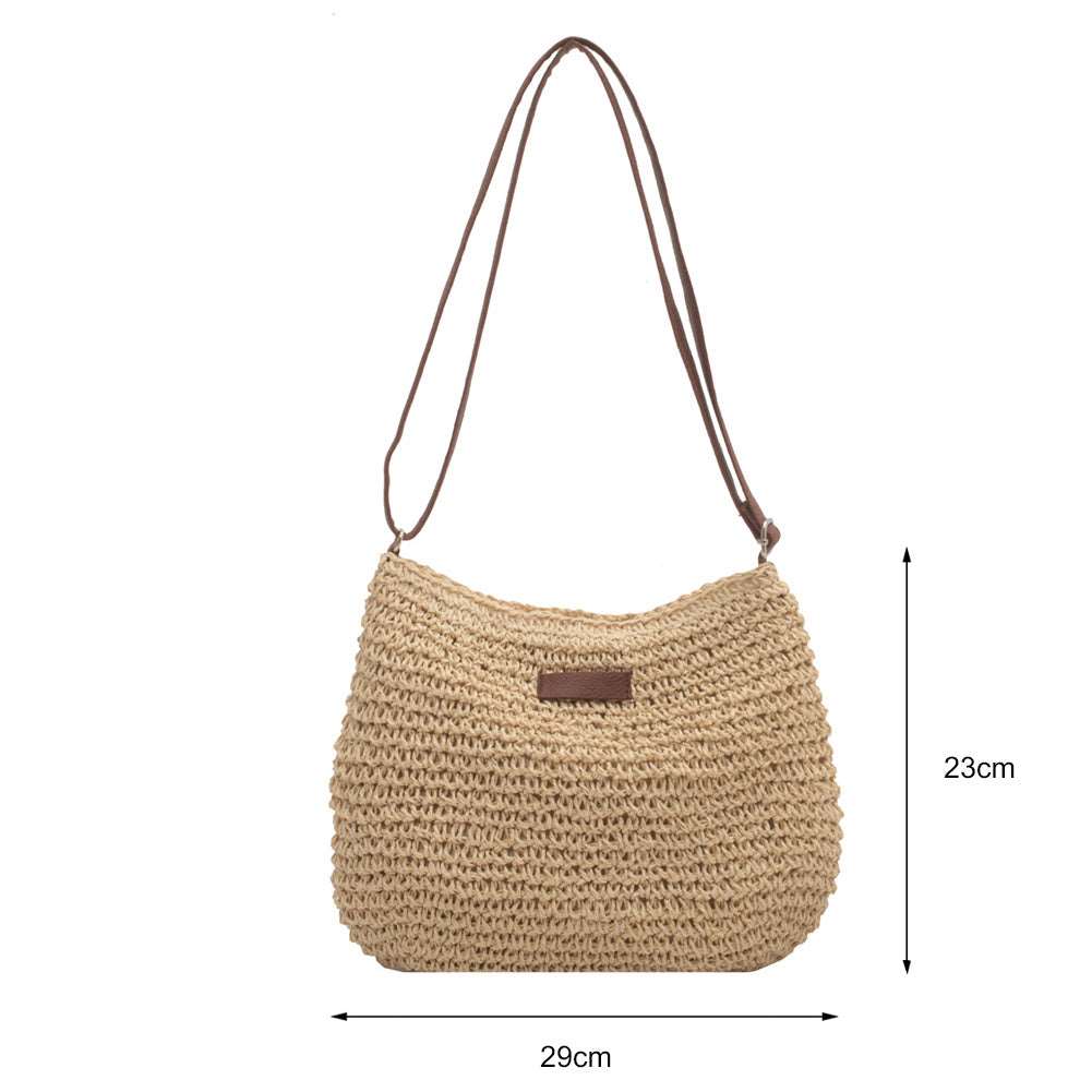 The HalleBeauty Vacation Straw Tote Bag, perfect for beach trips, is elegantly displayed against a white background. Made from woven straw, it measures 29 cm wide by 23 cm high and features a long strap and a small leather patch on the front—ideal for travel.