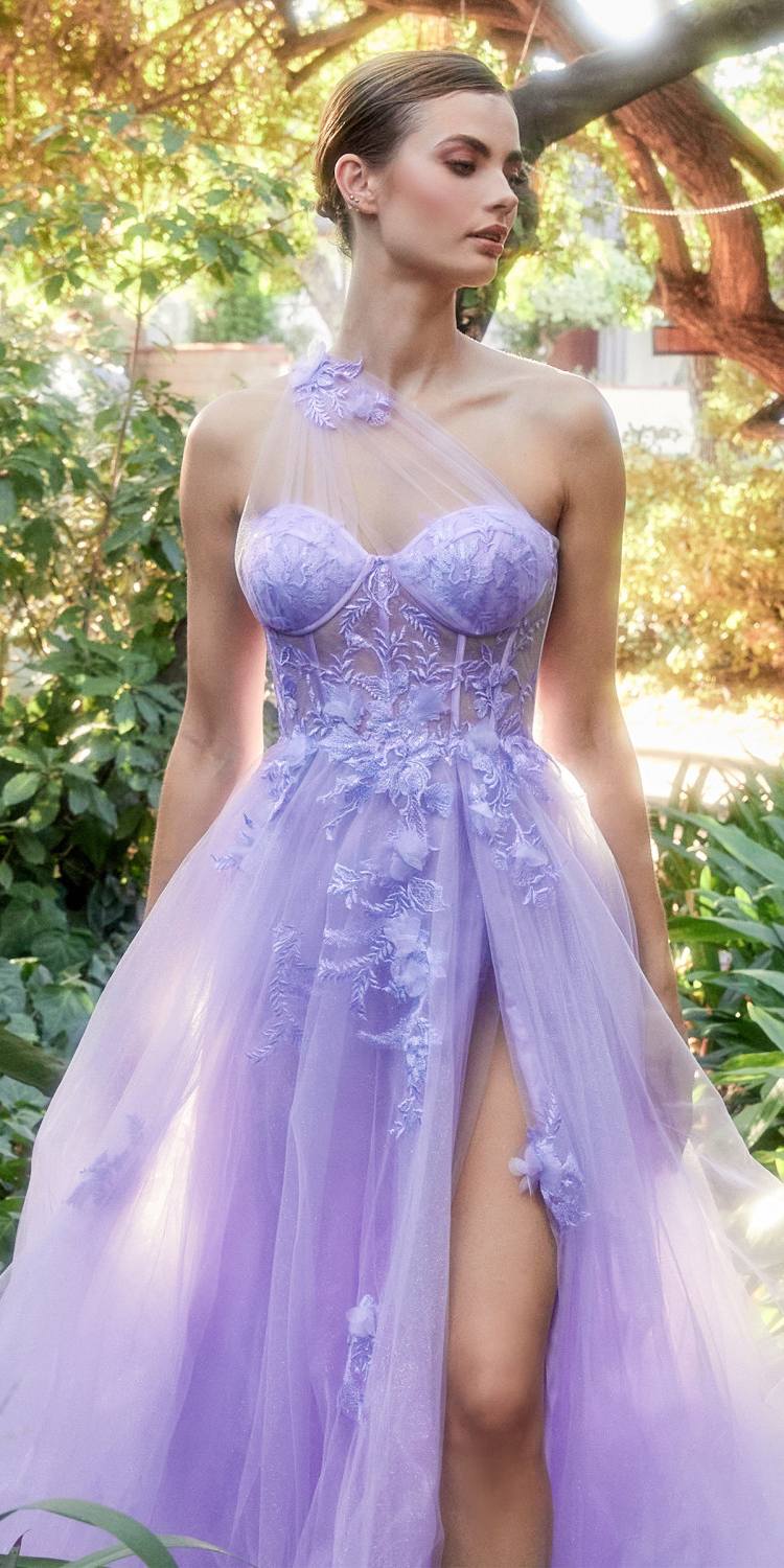 Woman wearing a purple evening gown with floral details in an outdoor setting.