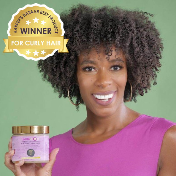 Woman holding a purple jar with a hair product, against a green background, featuring a 'Harper's Bazaar Best Product Winner' badge.